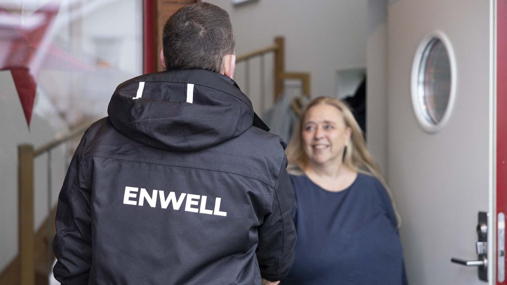 Ryggen på person som skakar i hand med kvinna i blå tröja